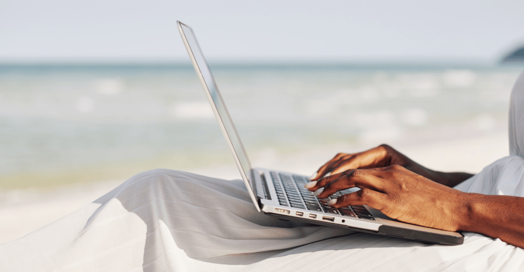 Productive person working on the beach with a laptop