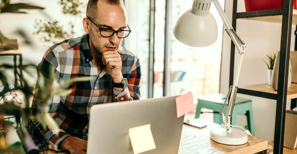 Freelancer sitting alone in a room, feeling isolated while working remotely