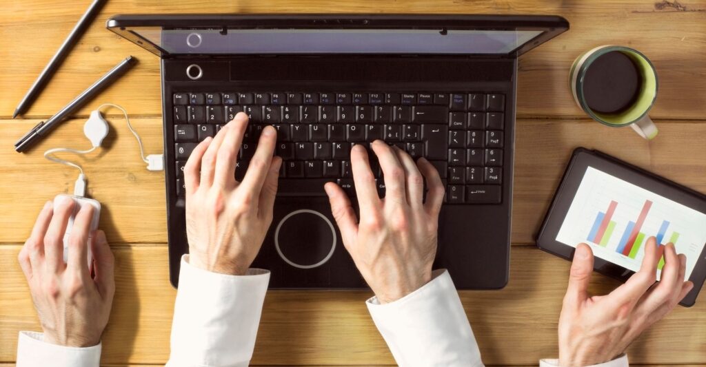 A remote worker multitasking and feeling burnout.