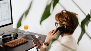 Stressed remote worker surrounded by devices, struggling to concentrate