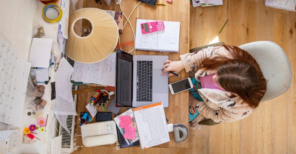 Remote worker distracted by smartphone while trying to focus on laptop task